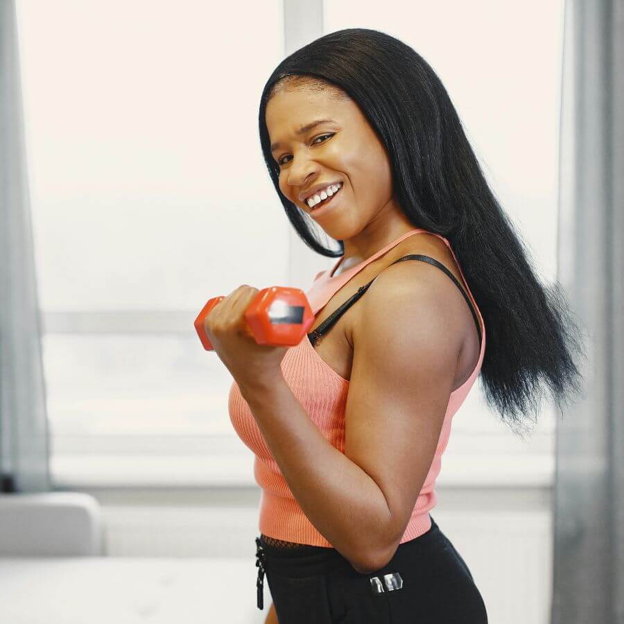 Woman over 40 holding dumbbells for strength training at home