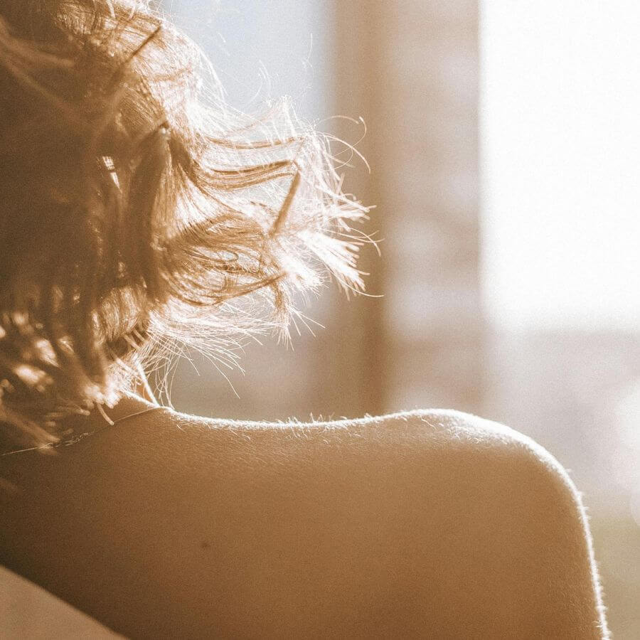Woman doing gentle morning stretches beside a mat